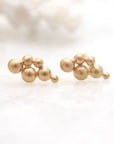 Gold bead earrings on a light background