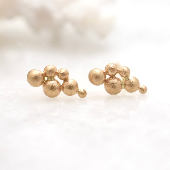 Gold bead earrings on a light background
