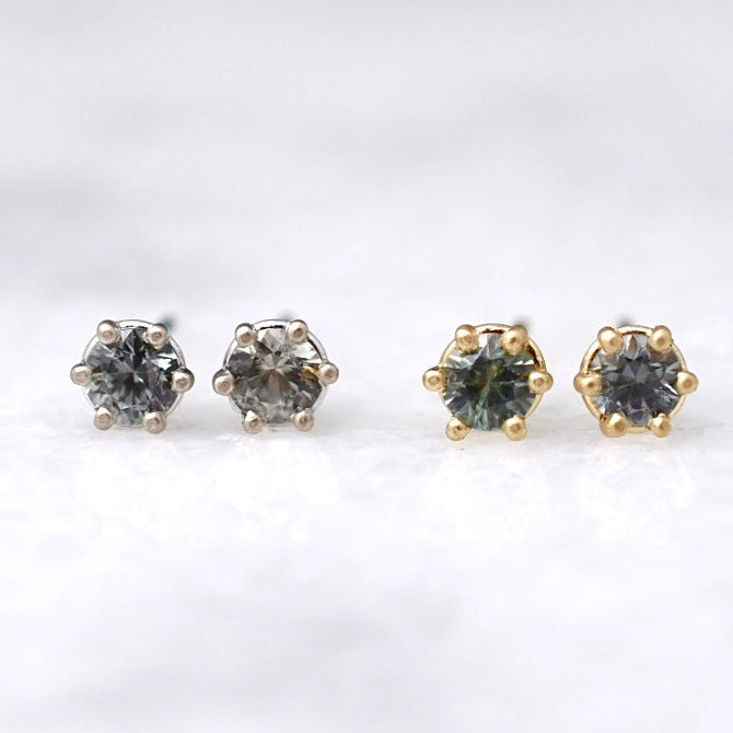 Four diamond stud earrings on a white background